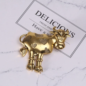 Detail of vintage gold bull brooch with heart motif on marble background