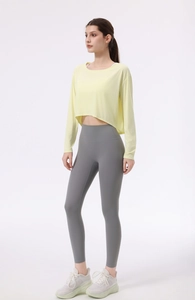 Detail von hellgelbem Yoga-Überzieher mit unregelmäßigem Saum und grauen Leggings