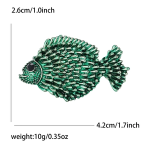 Detailed size view of green enamel fish brooch with black gem eye and scale texture