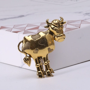 Detailed macro shot of a vintage gold alloy ox brooch with heart-shaped engraved patterns