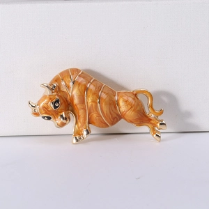 Detailed close-up of bull brooch with orange marble enamel and golden metal accents