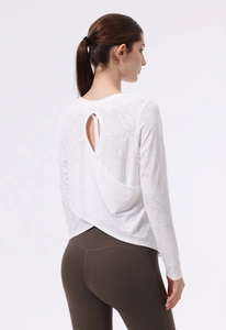 Dettaglio della maglia da yoga bianca a maniche lunghe con elegante design aperto sul retro