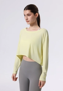 Detail eines hellgelben Yoga-Crop-Tops mit geschwungenem Saum und atmungsaktivem Netz