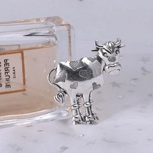 Close-up of vintage silver ox brooch with heart patterns on a white sequin fabric background