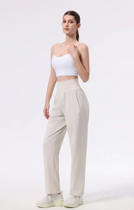 Full view of beige high-waisted yoga pants and white sports bra on a model