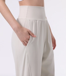 Detail view of high waisted yoga pants featuring side pockets in creamy white fabric