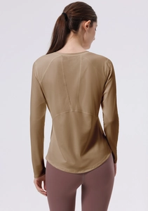 Detail view of khaki long sleeve yoga top with ergonomic stitching and racerback design