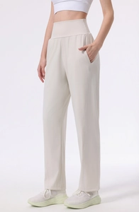 Detailed view of high-waisted yoga pants with side pockets in cream beige color
