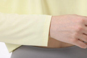 Detail der Flachnähte am gelben Yoga-Oberteil-Ärmel mit strukturiertem Stoff