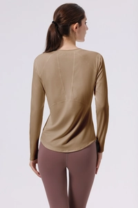 Macro view of seamless V-shaped back stitching on brown long sleeve yoga top