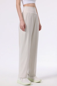 Side view of beige high-waisted wide-leg yoga pants with a relaxed straight-cut design