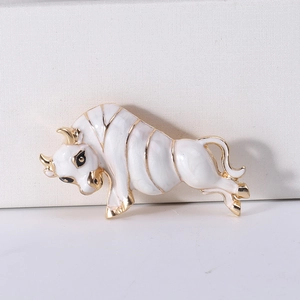 Macro shot of vintage ox brooch showing white enamel finish and gold-plated details