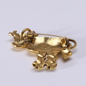 Vintage gold alloy ox brooch showing the back metal texture and safety pin clasp