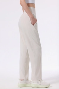 Detail view of high waisted beige yoga pants showing the side pocket and matte fabric texture