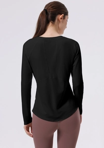 Detail view of black yoga top featuring curved hem and V-shaped back stitching detail