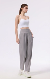 Detail view of high waist loose yoga pants and white crop top on model in studio