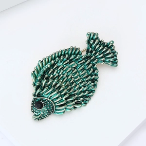 Close-up of green fish brooch with scale texture and black gemstone eye detail
