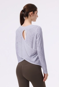 Dettaglio maglia da yoga jacquard a maniche lunghe con design a incrocio sulla schiena aperta
