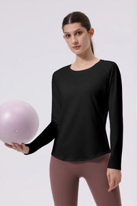 Detail of slim fit black yoga top and pink high-waist leggings with yoga ball accessory