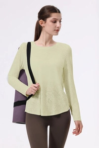 Dettaglio del tessuto jacquard traspirante su un top da yoga a maniche lunghe giallo chiaro