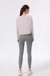 Rückansicht eines lockeren rosa Yoga-Überziehers und grauer Leggings für das Training