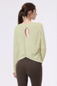 Dettaglio del design incrociato sulla schiena di un top da yoga jacquard verde chiaro