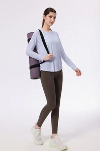 Dettaglio del top da yoga lavanda e leggings marroni con porta tappetino da yoga