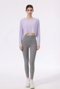 Detailansicht des lila Yoga-Oberteils mit grauer High-Waist-Leggings für Damen beim Sport