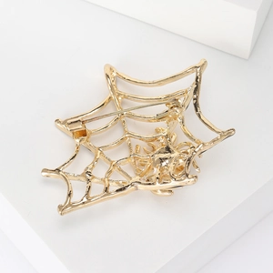 Macro shot showing the secure pin fastener on the back of the golden spider web brooch