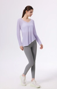 Dettaglio del top da yoga lilla con scollo a V e orlo asimmetrico e leggings grigi scuri