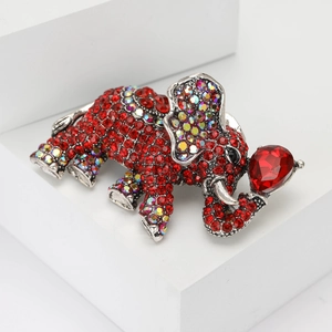 Spilla elefante elegante con strass rossi su un piedistallo di pietra geometrica