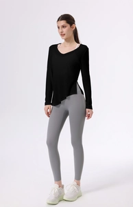 Dettaglio top sportivo a maniche lunghe con scollo a V, spacco laterale e leggings grigi a vita alta