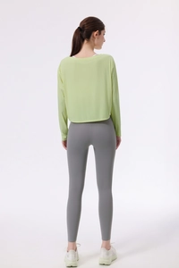 Detailansicht der blassgrünen Yoga-Hülle und der grauen Leggings mit hoher Taille
