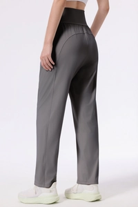 Detail of high-waisted dark grey yoga pants with sculpting back seam and straight leg cut