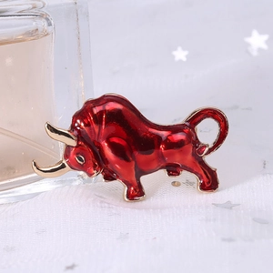 Close-up of a red enamel bull brooch with gold accents on a white star mesh background