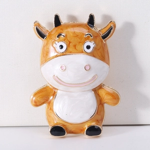 Macro view of cute cartoon calf brooch with orange marble texture and enamel details