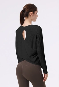 Dettaglio del top da yoga nero a maniche lunghe con design a incrocio e spacco sul retro