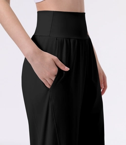 Close-up of black high-waisted sports pants with functional side pocket and elastic fabric