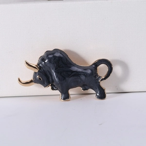 Macro shot of bull brooch with black marble enamel texture and golden metal accents