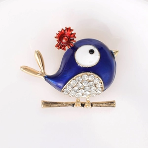 Detailed view of bird brooch with blue enamel wings and sparkling white rhinestones