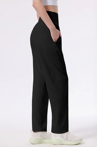 Detail view of high waisted black yoga pants with functional side pockets on female model
