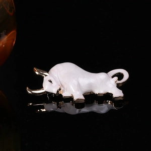 Macro shot of bull brooch with white enamel finish and golden metallic details