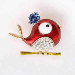 Detailed view of enamel bird brooch with red wings, blue flowers and white rhinestones