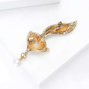 Golden fox brooch back view with alloy texture, safety pin and white pearl pendant