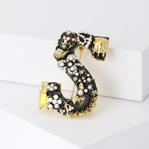 Broche lettre S dorée avec émail noir, perles et accents de strass au style vintage