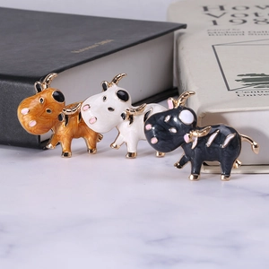 Broches vache en émail mignonnes en orange, blanc et noir avec détails dorés