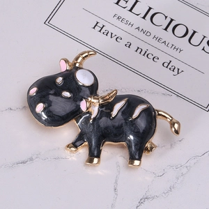 Gros plan détaillé d'une broche en émail en forme de vache avec des accents dorés