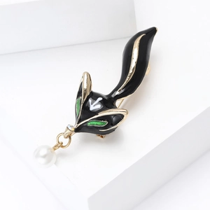 Detail of fox brooch with black enamel finish and hanging white pearl pendant