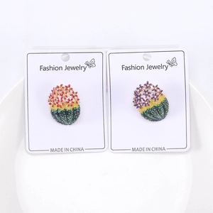 Détail de broches cactus en émail coloré avec strass sur une carte de support