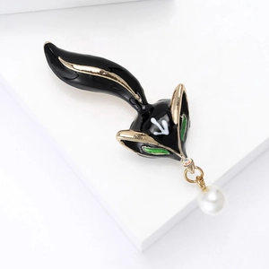 Detailed macro shot of an alloy fox brooch featuring black enamel and a white pearl pendant